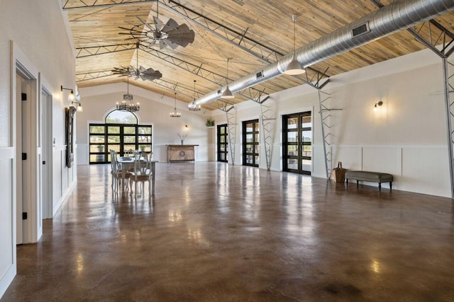 25404 Hamilton Pool Rd, Round Mountain, TX 78663 - misc room with high vaulted ceiling, concrete floors, a chandelier, french doors, and a wainscoted wall