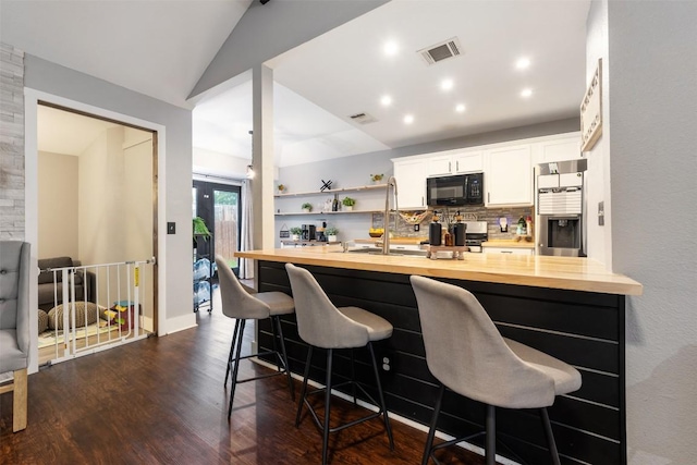 1003 Buttercup Ct, Leander, TX 78641 - kitchen with black microwave, stainless steel fridge with ice dispenser, butcher block counters, a breakfast bar area, and white cabinetry