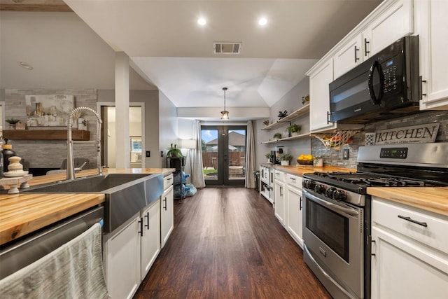 1003 Buttercup Ct, Leander, TX 78641 - kitchen with appliances with stainless steel finishes, wood counters, french doors, recessed lighting, and lofted ceiling