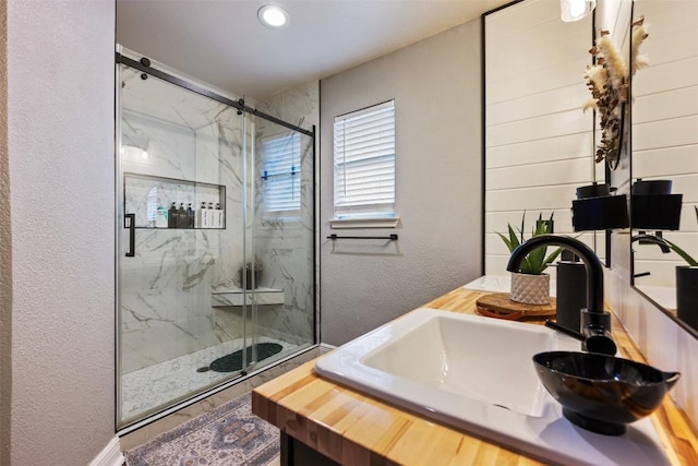 1003 Buttercup Ct, Leander, TX 78641 - full bathroom featuring a marble finish shower, a textured wall, vanity, and recessed lighting