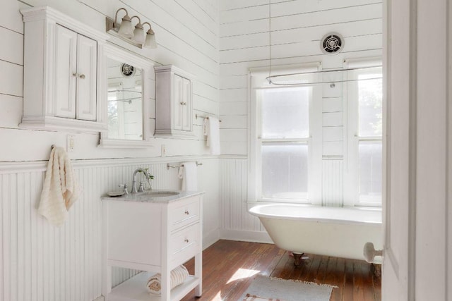 1211 E 13th St, Austin, TX 78702 - full bathroom featuring a soaking tub, vanity, hardwood / wood-style flooring, and wooden walls
