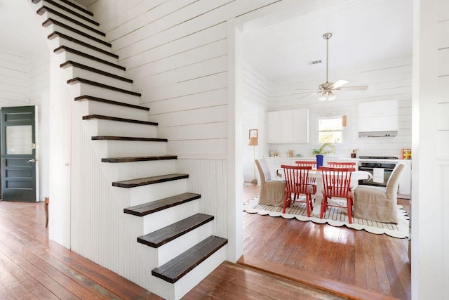 1211 E 13th St, Austin, TX 78702 - stairs with hardwood / wood-style flooring, a ceiling fan, and wood walls