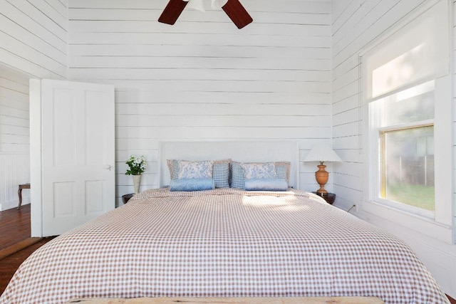 1211 E 13th St, Austin, TX 78702 - bedroom with wooden walls, wood finished floors, and a ceiling fan