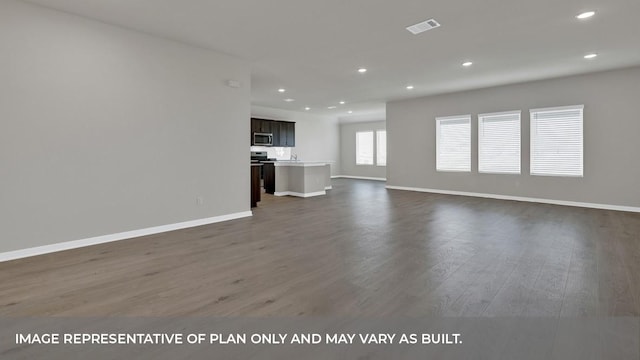 362 Barron Estate Dr, Lockhart, TX 78644 - unfurnished living room with dark wood finished floors, baseboards, and recessed lighting