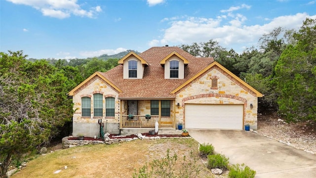 1454 Rose Ln, Canyon Lake, TX 78133 - french country inspired facade with stone siding, a porch, driveway, roof with shingles, and an attached garage