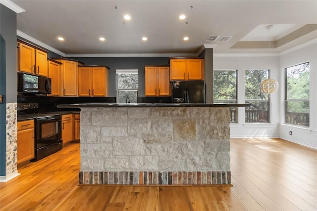 1454 Rose Ln, Canyon Lake, TX 78133 - kitchen featuring black appliances, crown molding, a center island, dark countertops, and light wood-style floors