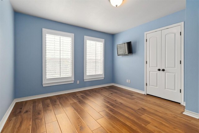 1454 Rose Ln, Canyon Lake, TX 78133 - unfurnished bedroom featuring baseboards, wood finished floors, and a closet