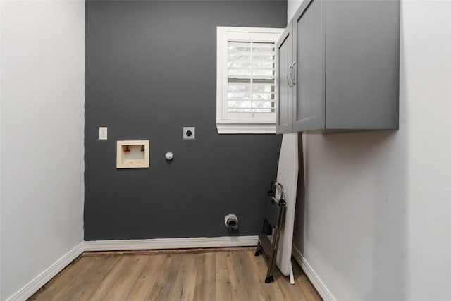 1454 Rose Ln, Canyon Lake, TX 78133 - washroom with electric dryer hookup, light wood-style floors, baseboards, cabinet space, and washer hookup