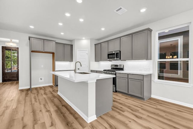 1621 Coral Sunrise Aly, Leander, TX 78641 - kitchen featuring appliances with stainless steel finishes, gray cabinetry, a sink, light wood-style floors, and recessed lighting