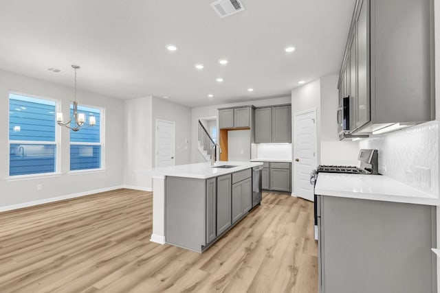 1621 Coral Sunrise Aly, Leander, TX 78641 - kitchen featuring stainless steel appliances, gray cabinetry, a sink, recessed lighting, and light wood-type flooring