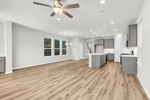 1621 Coral Sunrise Aly, Leander, TX 78641 - kitchen featuring gray cabinets, a sink, a chandelier, open floor plan, and recessed lighting