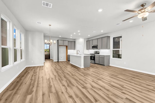 1621 Coral Sunrise Aly, Leander, TX 78641 - kitchen featuring gray cabinets, appliances with stainless steel finishes, open floor plan, a chandelier, and recessed lighting
