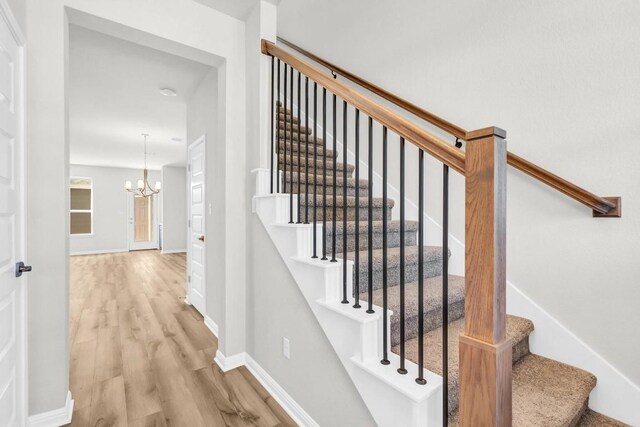 1621 Coral Sunrise Aly, Leander, TX 78641 - stairs featuring wood finished floors, a chandelier, and baseboards