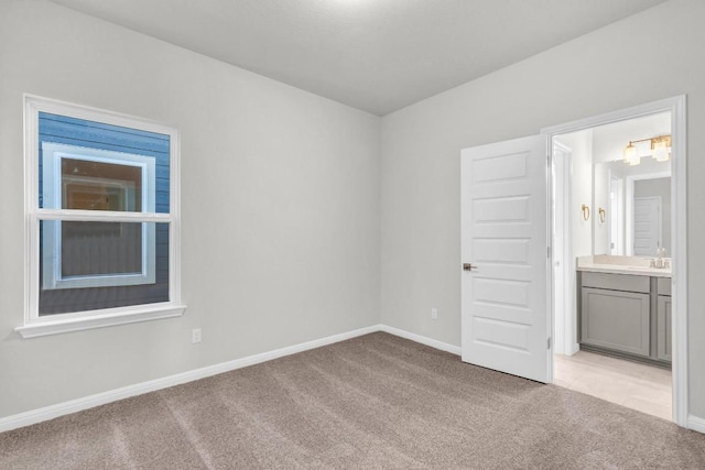1621 Coral Sunrise Aly, Leander, TX 78641 - unfurnished bedroom with light carpet, baseboards, and ensuite bath