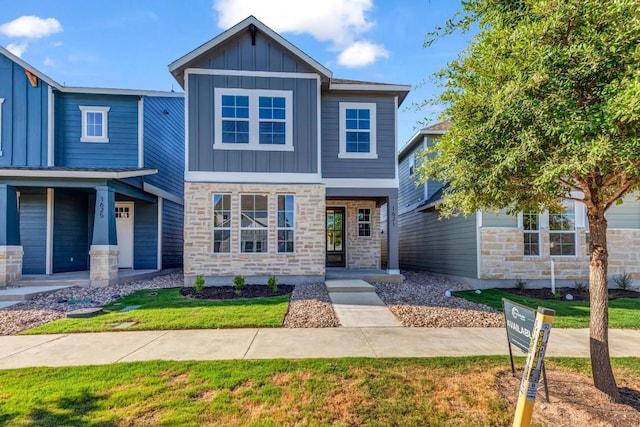 1621 Coral Sunrise Aly, Leander, TX 78641 - view of front facade featuring board and batten siding, stone siding, and a porch