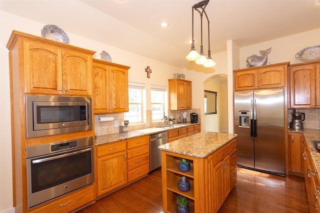 1367 Indian Pass, Salado, TX 76571 - kitchen featuring stainless steel appliances, tasteful backsplash, arched walkways, light stone counters, and a sink
