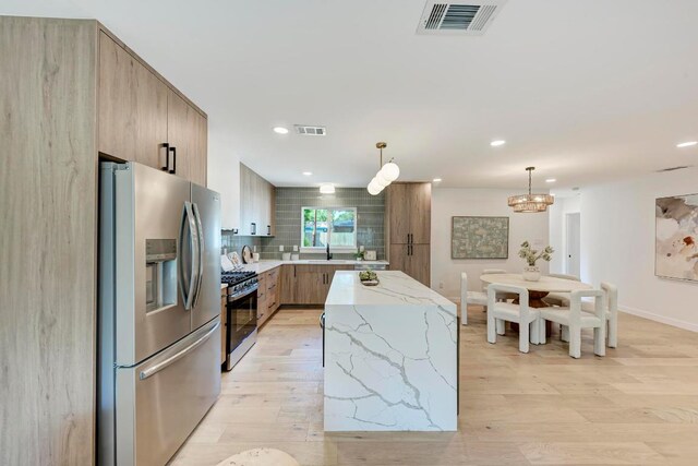 1314 Ridgemont Dr, Austin, TX 78723 - kitchen with stainless steel fridge, gas range oven, modern cabinets, light wood-type flooring, and recessed lighting