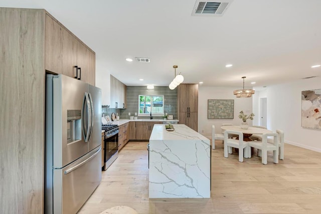 1314 Ridgemont Dr, Austin, TX 78723 - kitchen featuring appliances with stainless steel finishes, modern cabinets, light wood-style floors, decorative backsplash, and recessed lighting