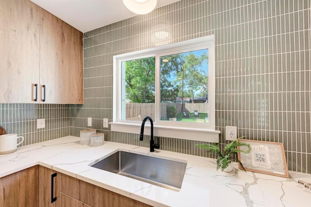 1314 Ridgemont Dr, Austin, TX 78723 - kitchen featuring a sink, light stone counters, and decorative backsplash