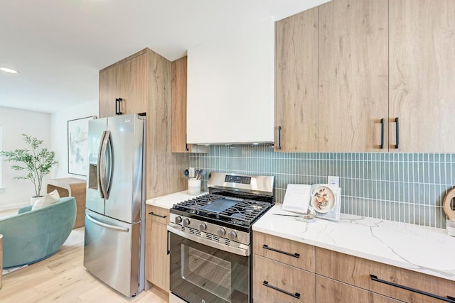 1314 Ridgemont Dr, Austin, TX 78723 - kitchen featuring stainless steel appliances, light stone counters, light wood-style flooring, backsplash, and light brown cabinets