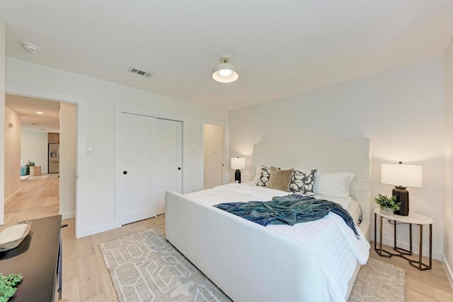 1314 Ridgemont Dr, Austin, TX 78723 - bedroom featuring light wood finished floors, stainless steel fridge with ice dispenser, a closet, and baseboards