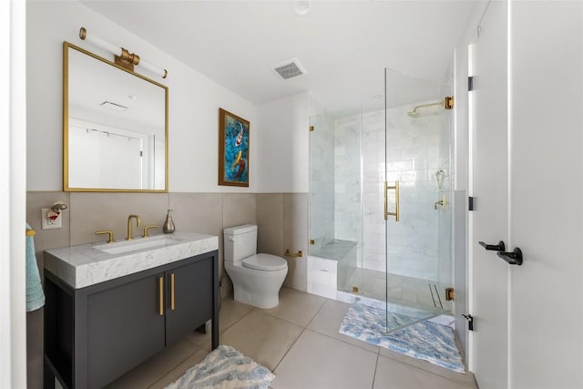 70 Rainey St Unit 2106, Austin, TX 78701 - bathroom with tile walls, vanity, a stall shower, and tile patterned flooring