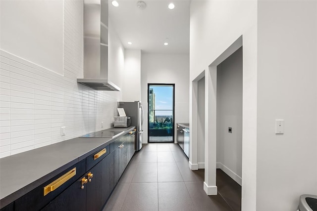 70 Rainey St Unit 2106, Austin, TX 78701 - kitchen with wall chimney range hood, decorative backsplash, black electric stovetop, recessed lighting, and dark countertops