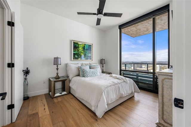 70 Rainey St Unit 2106, Austin, TX 78701 - bedroom with light wood-type flooring, a ceiling fan, and floor to ceiling windows