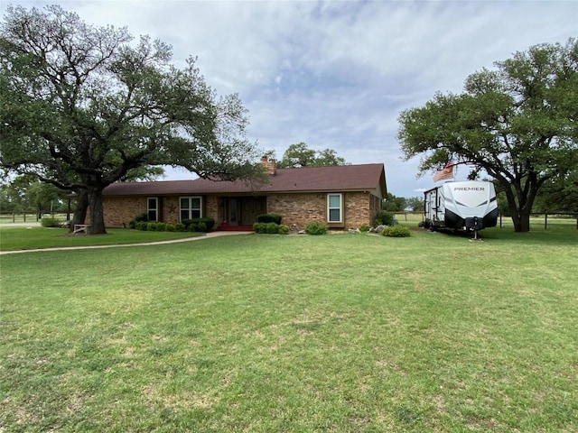 140 Oakridge Rd, Georgetown, TX 78628 - view of front facade featuring a front lawn, a chimney, and brick siding