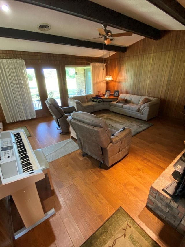 140 Oakridge Rd, Georgetown, TX 78628 - living room with wood finished floors, wooden walls, a ceiling fan, and beam ceiling