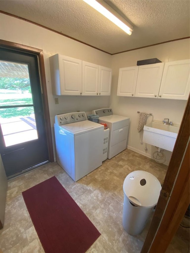 140 Oakridge Rd, Georgetown, TX 78628 - laundry area with cabinet space, washing machine and dryer, a textured ceiling, and light floors