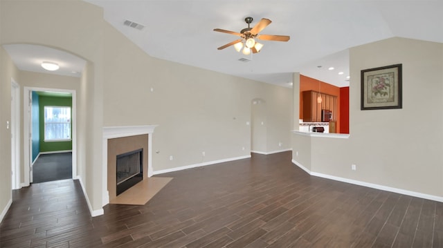 18409 Hees Ln, Pflugerville, TX 78660 - unfurnished living room featuring ceiling fan, dark wood-type flooring, baseboards, a fireplace with flush hearth, and vaulted ceiling