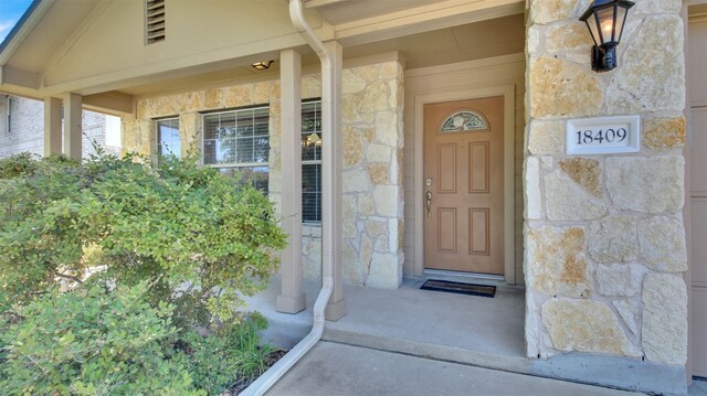 18409 Hees Ln, Pflugerville, TX 78660 - doorway to property featuring stone siding and a porch