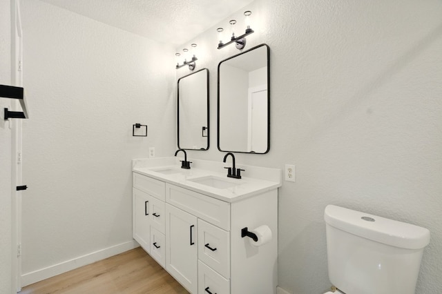 179 Pimlico, Kyle, TX 78640 - bathroom featuring toilet, wood finished floors, double vanity, and baseboards