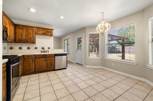 2511 Jacqueline Dr, Leander, TX 78641 - kitchen with appliances with stainless steel finishes, light countertops, a chandelier, decorative backsplash, and baseboards