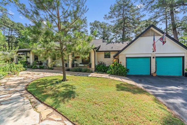 259 Akaloa Dr, Bastrop, TX 78602 - view of front facade with asphalt driveway, an attached garage, a front lawn, and stone siding