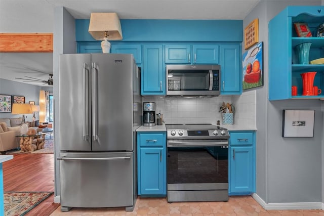 259 Akaloa Dr, Bastrop, TX 78602 - kitchen featuring stainless steel appliances, blue cabinets, light countertops, decorative backsplash, and a ceiling fan