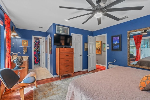 259 Akaloa Dr, Bastrop, TX 78602 - bedroom with wood finished floors, baseboards, ceiling fan, and a walk in closet