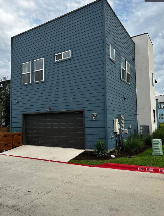 9015 Cattle Baron Path Unit 404, Austin, TX 78747 - view of side of property featuring an attached garage and cooling unit