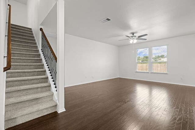 423 Sierra Mar Loop, Leander, TX 78641 - unfurnished living room featuring a ceiling fan, dark wood finished floors, and stairway