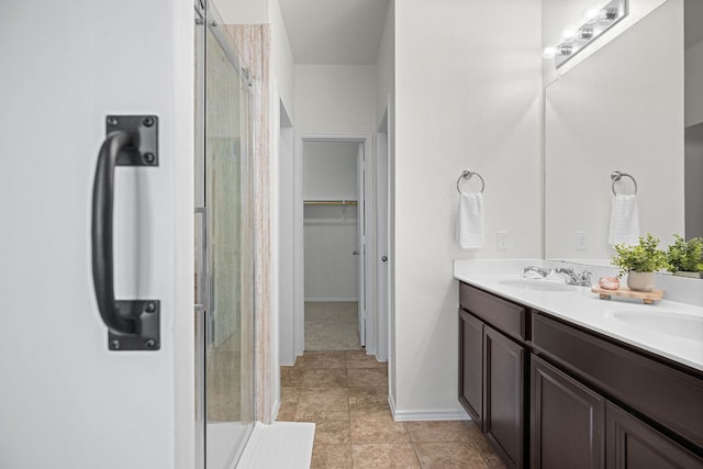 423 Sierra Mar Loop, Leander, TX 78641 - full bathroom featuring a stall shower, double vanity, a spacious closet, and tile patterned floors