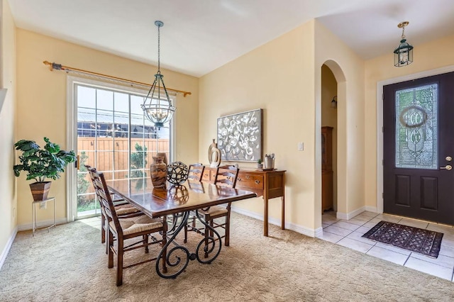 3824 Gaines Ct, Austin, TX 78735 - tiled dining space featuring carpet flooring, arched walkways, and a chandelier