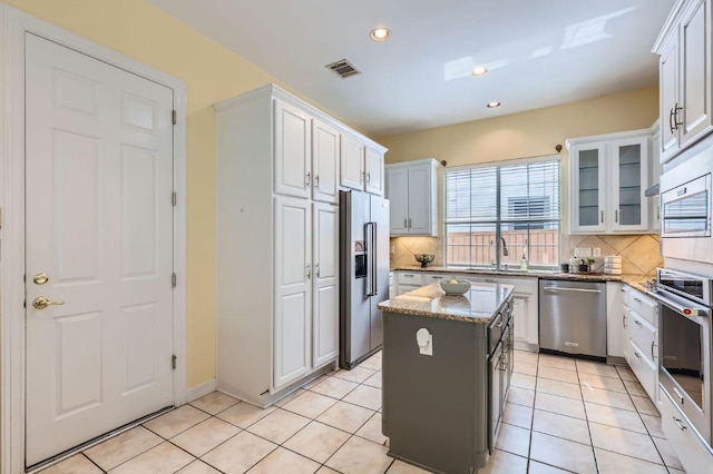3824 Gaines Ct, Austin, TX 78735 - kitchen with stainless steel appliances, tasteful backsplash, light stone counters, white cabinets, and recessed lighting