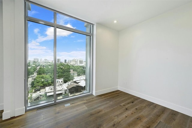 501 W Ave Unit 1104, Austin, TX 78701 - unfurnished room featuring a wall of windows, healthy amount of natural light, a city view, wood finished floors, and recessed lighting