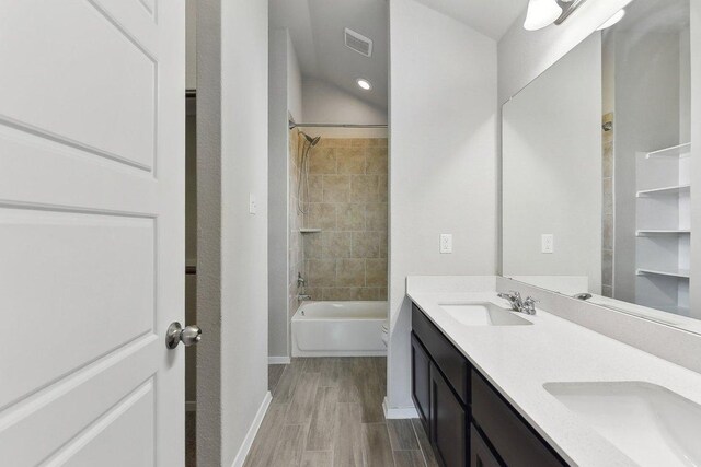 116 Saranac Dr, Elgin, TX 78621 - bathroom featuring double vanity, shower / bath combination, baseboards, and wood finished floors