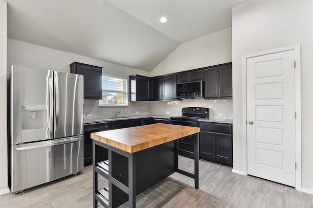 116 Saranac Dr, Elgin, TX 78621 - kitchen with black appliances, butcher block counters, a sink, vaulted ceiling, and light wood-style flooring