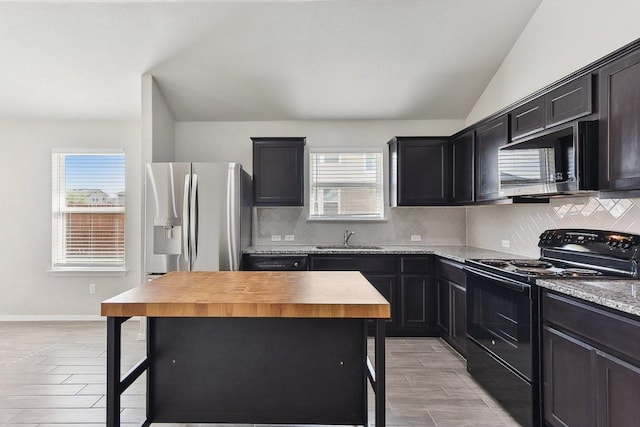 116 Saranac Dr, Elgin, TX 78621 - kitchen with appliances with stainless steel finishes, a sink, tasteful backsplash, light wood finished floors, and a kitchen island