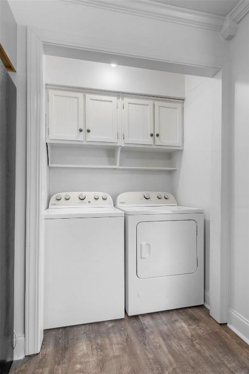 1125 Christie Dr, Austin, TX 78721 - laundry area with washing machine and dryer, cabinet space, crown molding, and wood finished floors