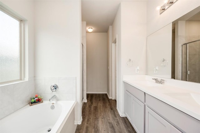 10701 Dimitrios Dr, Austin, TX 78747 - bathroom with a bath, double vanity, tiled shower, and wood finished floors