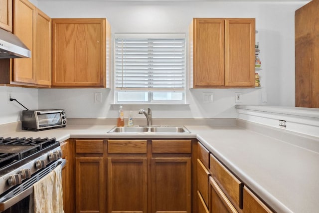 6412 Circulo De Amistad, Austin, TX 78741 - kitchen with a sink, under cabinet range hood, light countertops, and stainless steel range with gas stovetop